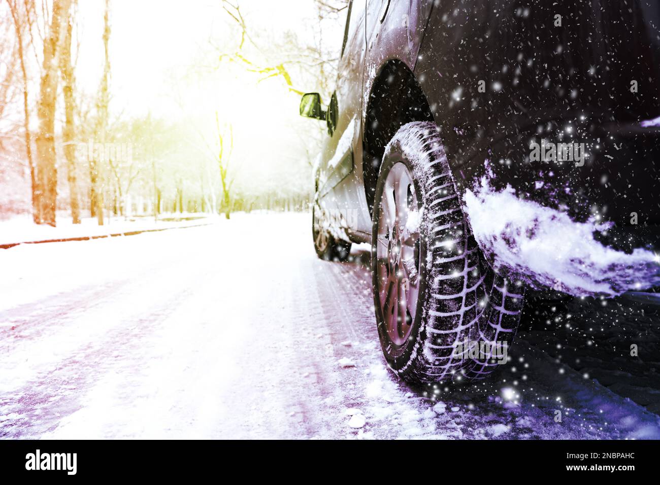 Modern car with winter tires on snowy road Stock Photo Alamy