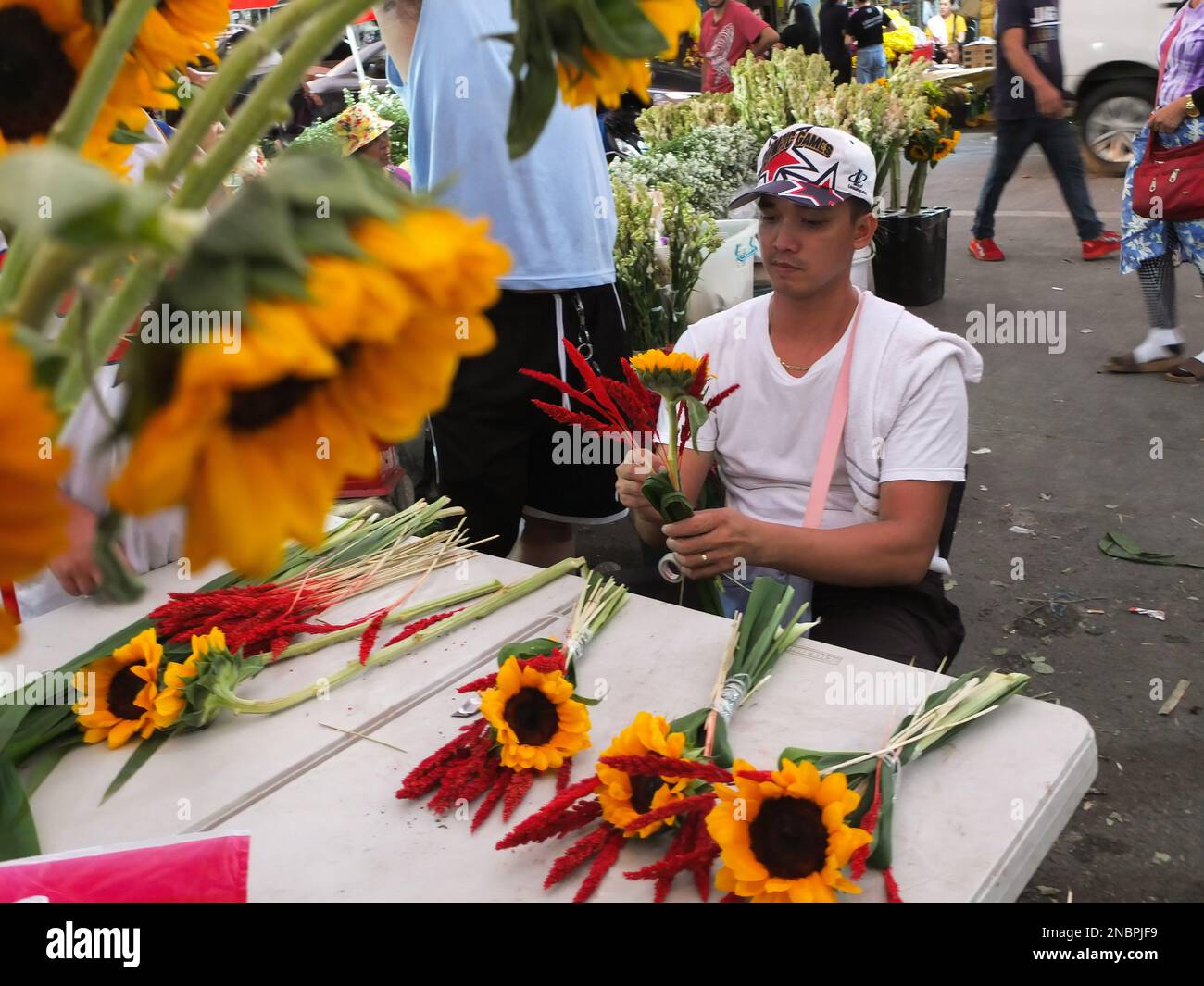 Dangwa 13 Feb 2023, A male florist seen arranging a sunflower bouquet