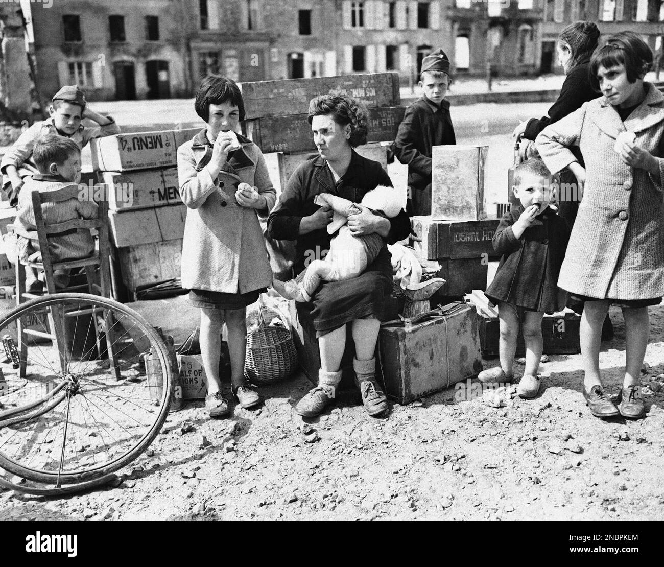 A French woman and her children wait in the Montebourg marketplace on ...