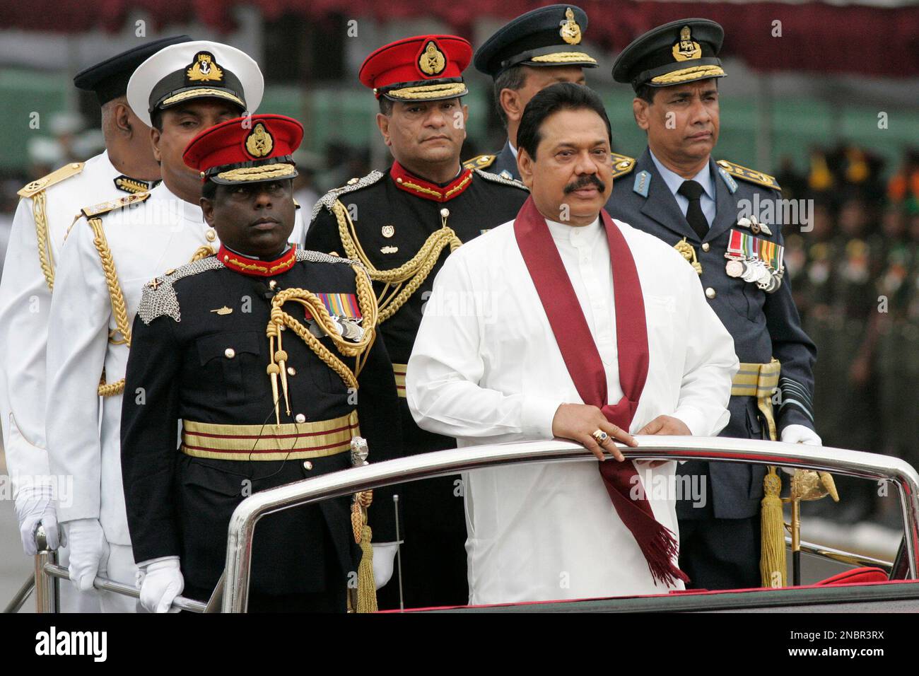 Sri Lankan President Mahinda Rajapaksa, wearing scarf, inspects a guard ...
