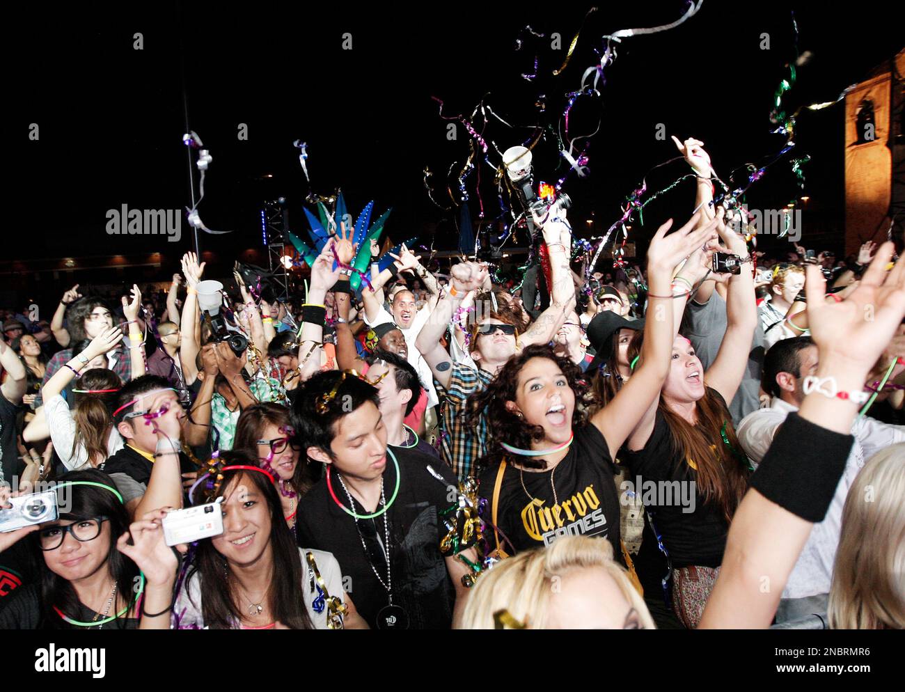Concert goers dance and reach for streamers during the Redfoo of LMFAO