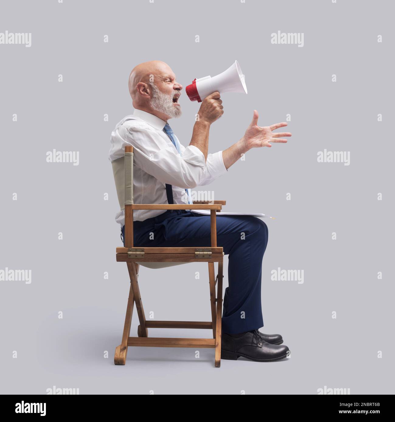 Film director sitting and shouting with a megaphone: film industry and