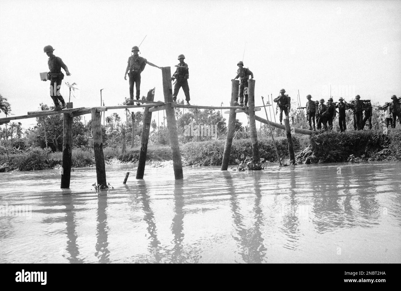 South Vietnamese infantrymen are silhouetted is they work their way ...