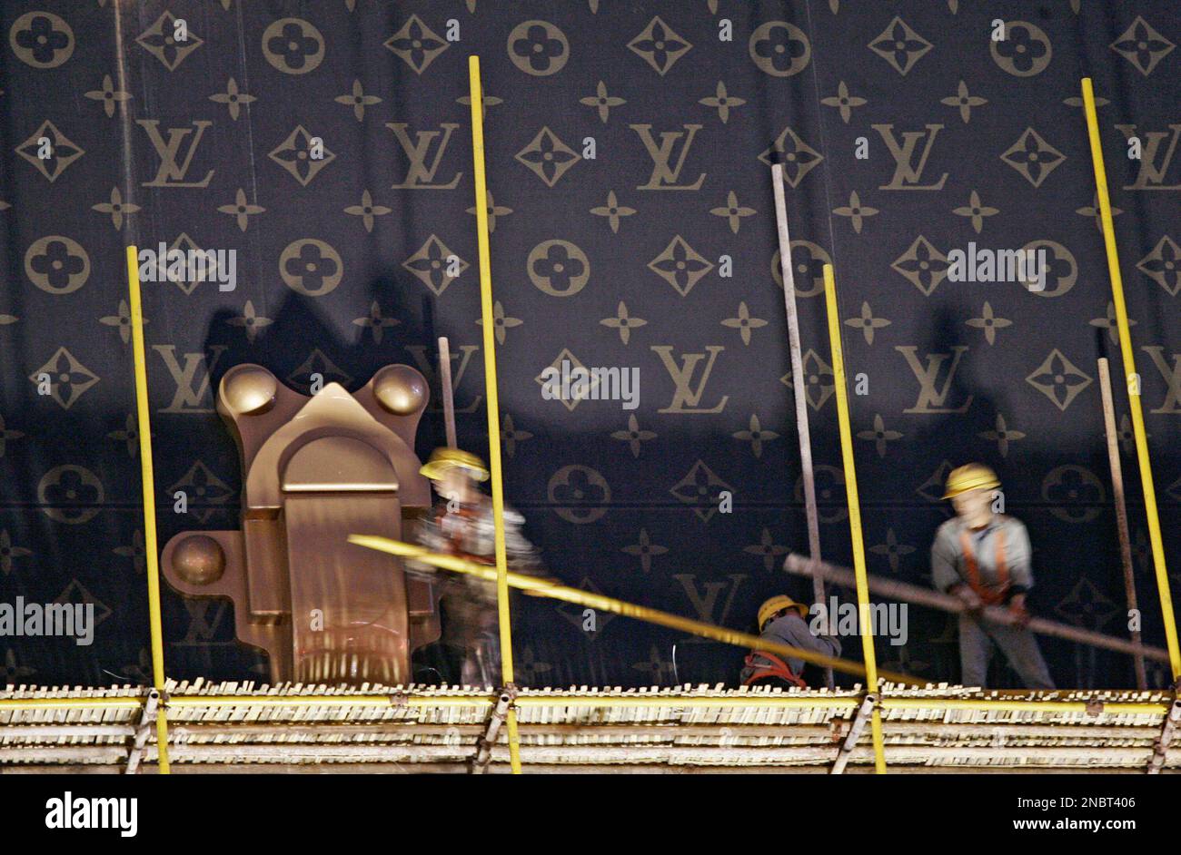 Workers dismantle a giant advertisement display modeling a Louis Vuitton  suitcase outside a Louis Vuitton branch on Thursday, May 19, 2011 in  Shanghai, China. Massive advertisements are being torn down because they