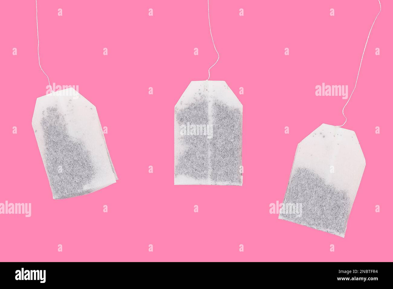 Black tea bag disposable, black tea bag disposable closeup on a pink background, Three white