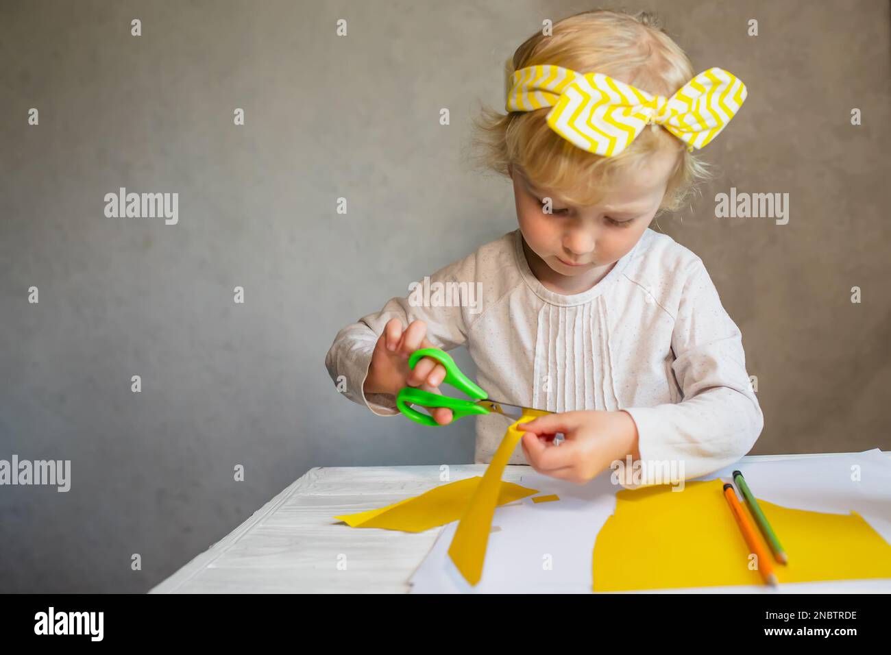 Stock Photo Child Cutting Yellow Construction Paper With Scissors