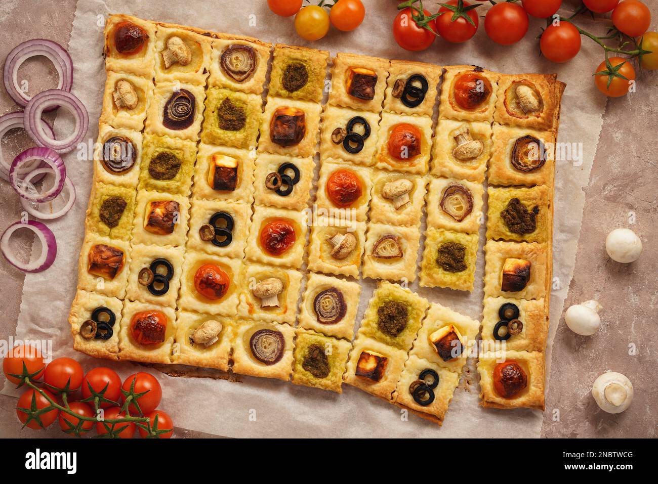 Puff pastry mini pies with cherry tomatoes, mushrooms, olives , feta cheese and onion Stock