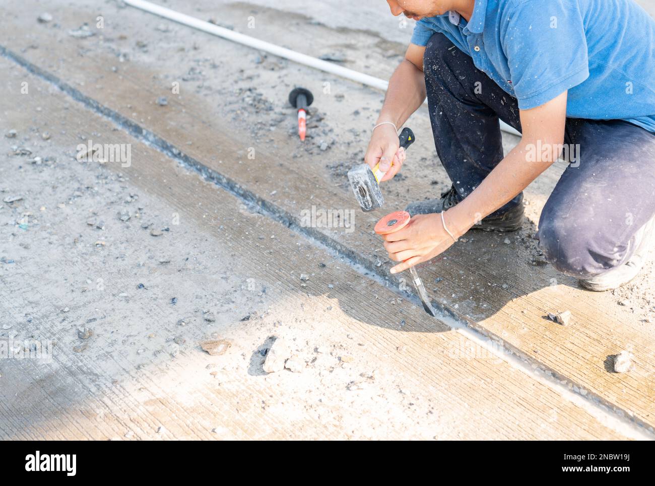 Construction labor working with hammer and Chisel dig concrete in a construction site Stock