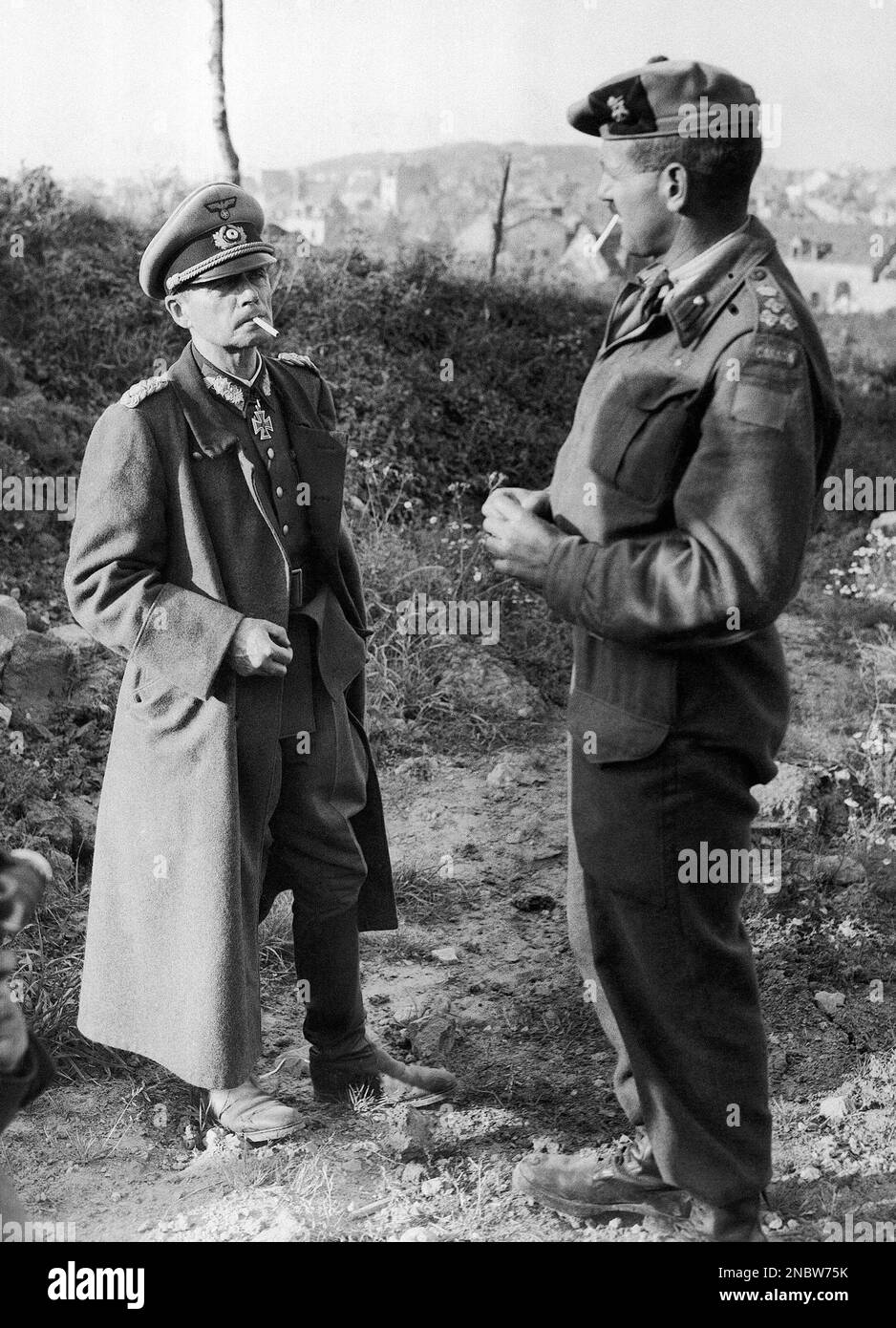 Lt. Gen. Ferdinand Heim, left, commander of the German Garrison at Boulogne on Sept. 28, 1944, gropes in his left pocket for a match as he talks with Brig. J. Rockingham, of Victoria, B.C., the Canadian commander who led the final assault against the garrison. The German general decked himself out in all his military finery before surrendering. (AP Photo) Stock Photo