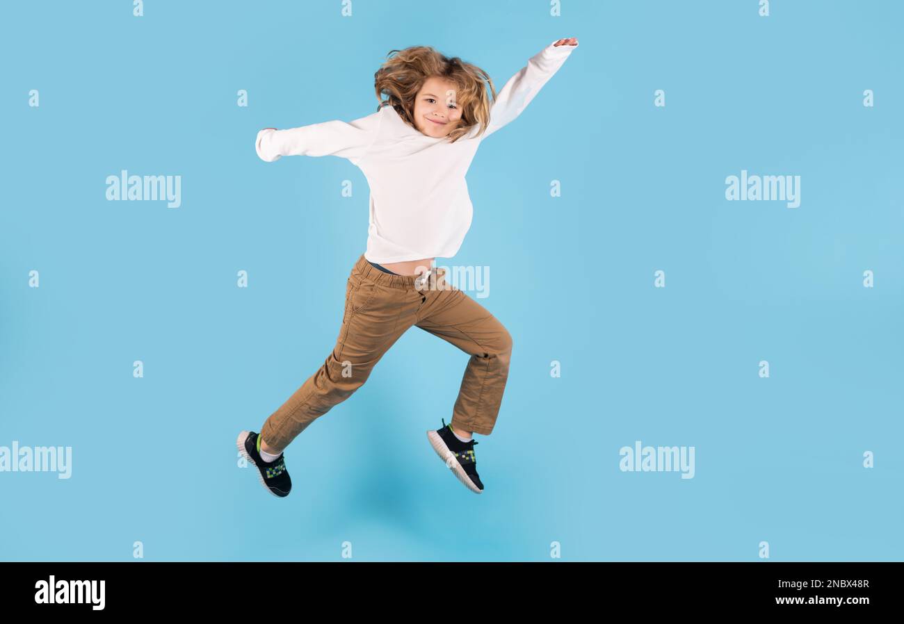 Funny boy jumping. Full length photo of kid boy jump high wear casual checkered shirt isolated on yellow background. Portrait of jumping boy. Kid jump Stock Photo