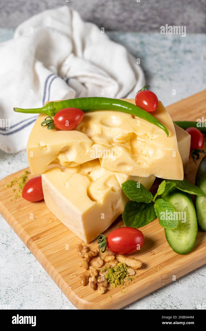 Gruyere cheese. Piece of Gruyere cheese on wooden cutting board. Cheese collection Stock Photo