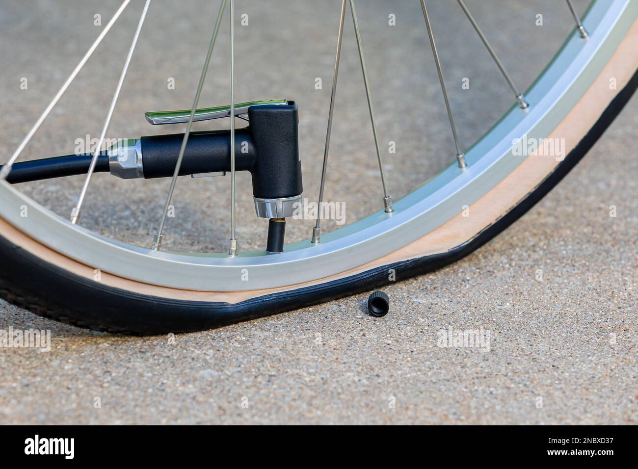 Inflating flat tire on bicycle with air pump. Bike maintenance, repair and cycling concept. Stock Photo