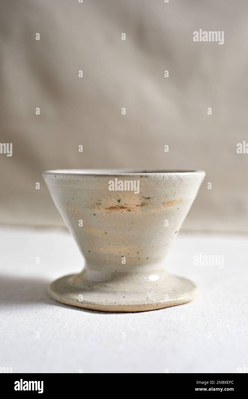 Handmade coffee dripper ceramic on  textile background. Stock Photo