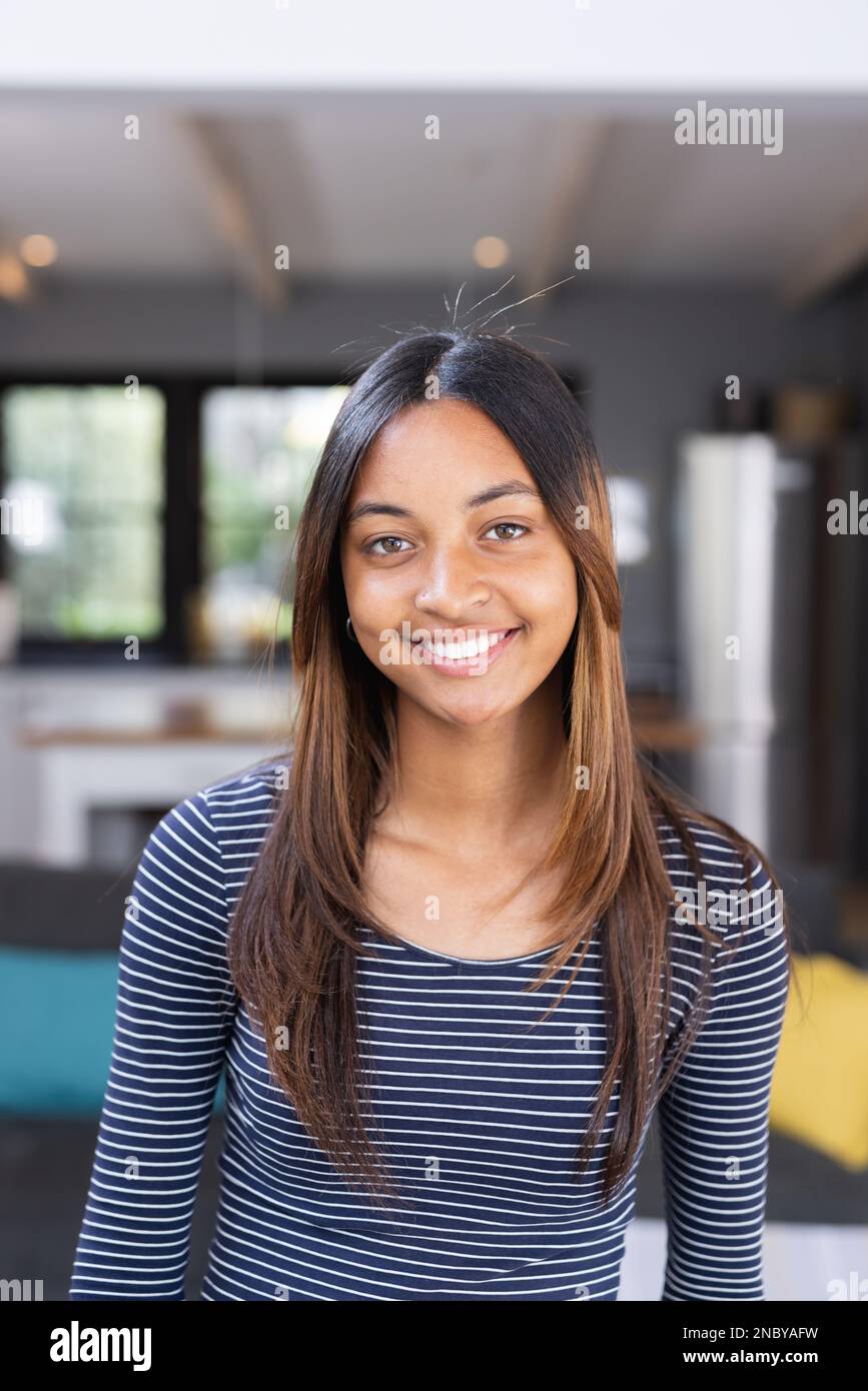 Portrait of happy biracial teenage girl smiling in kitchen. Spending quality time at home concept. Stock Photo