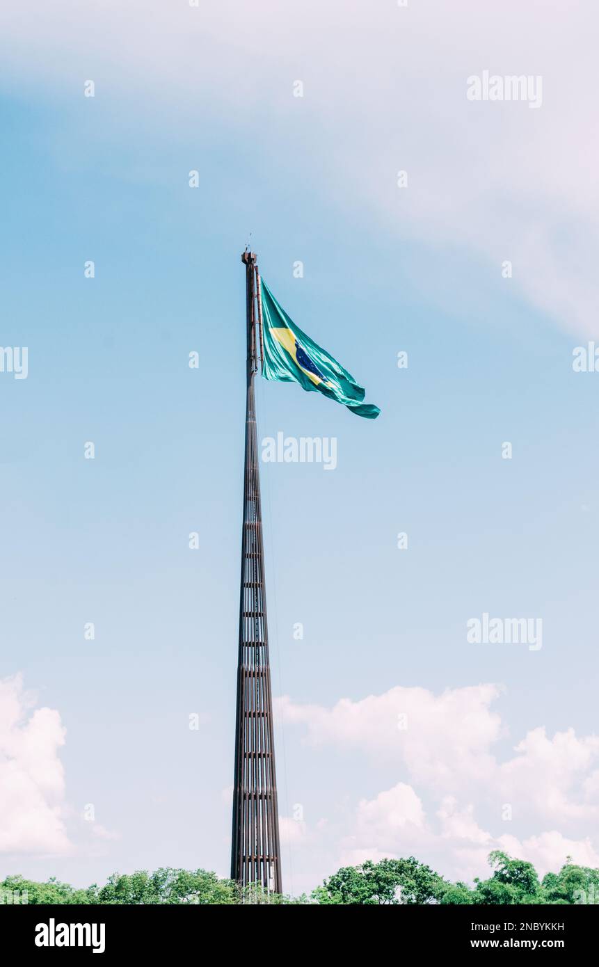 Brazilian flag flying, fluttering in the wind and with the blue sky in the background. Stock Photo