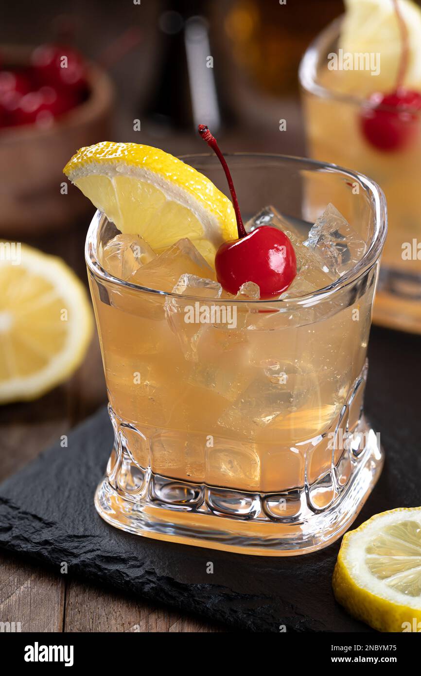 https://c8.alamy.com/comp/2NBYM75/whiskey-sour-cocktail-with-marachino-cherry-and-lemon-slice-on-black-slate-board-2NBYM75.jpg