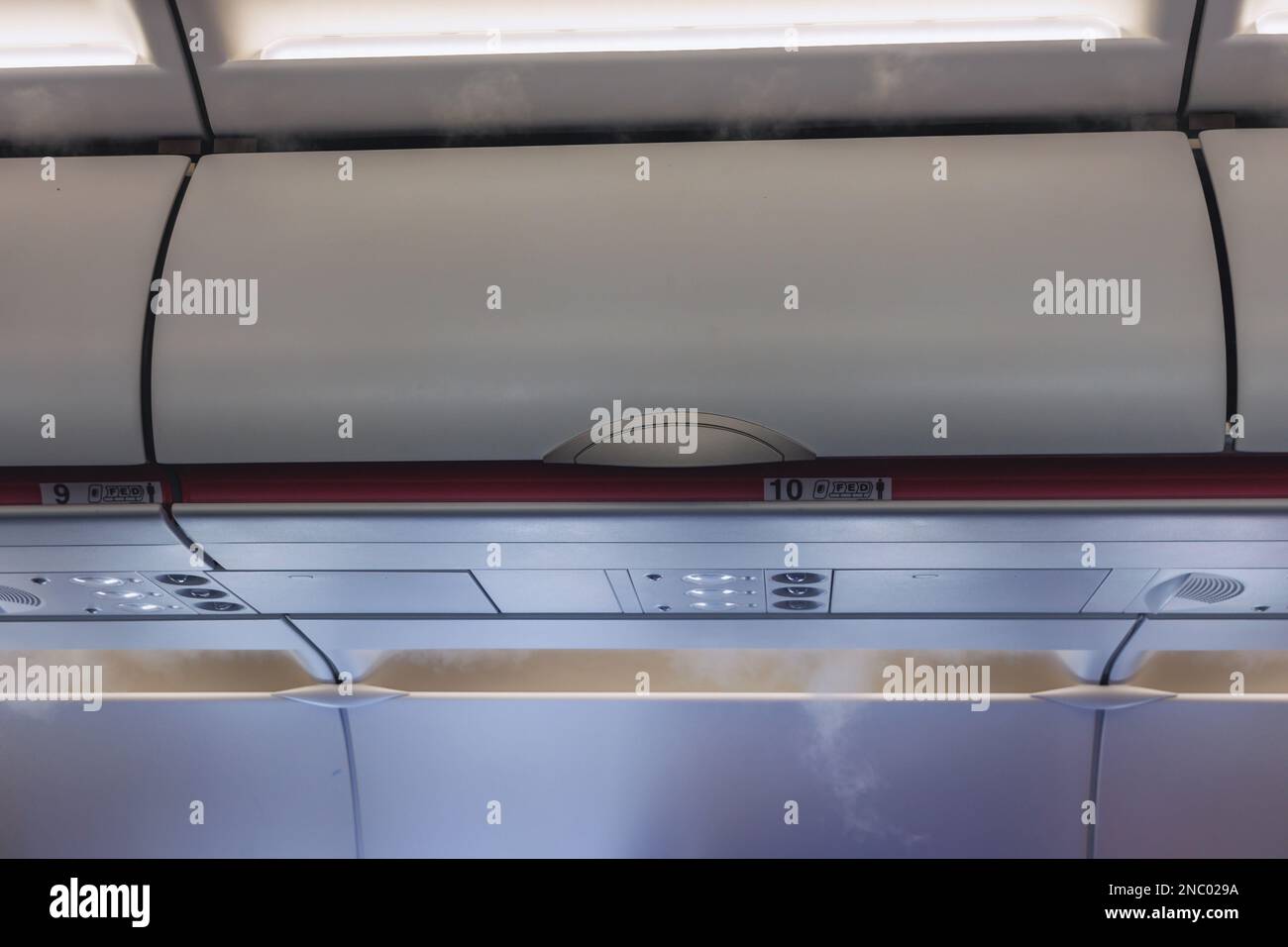 Closed hand luggage compartments in a cabin of passenger plane Stock ...