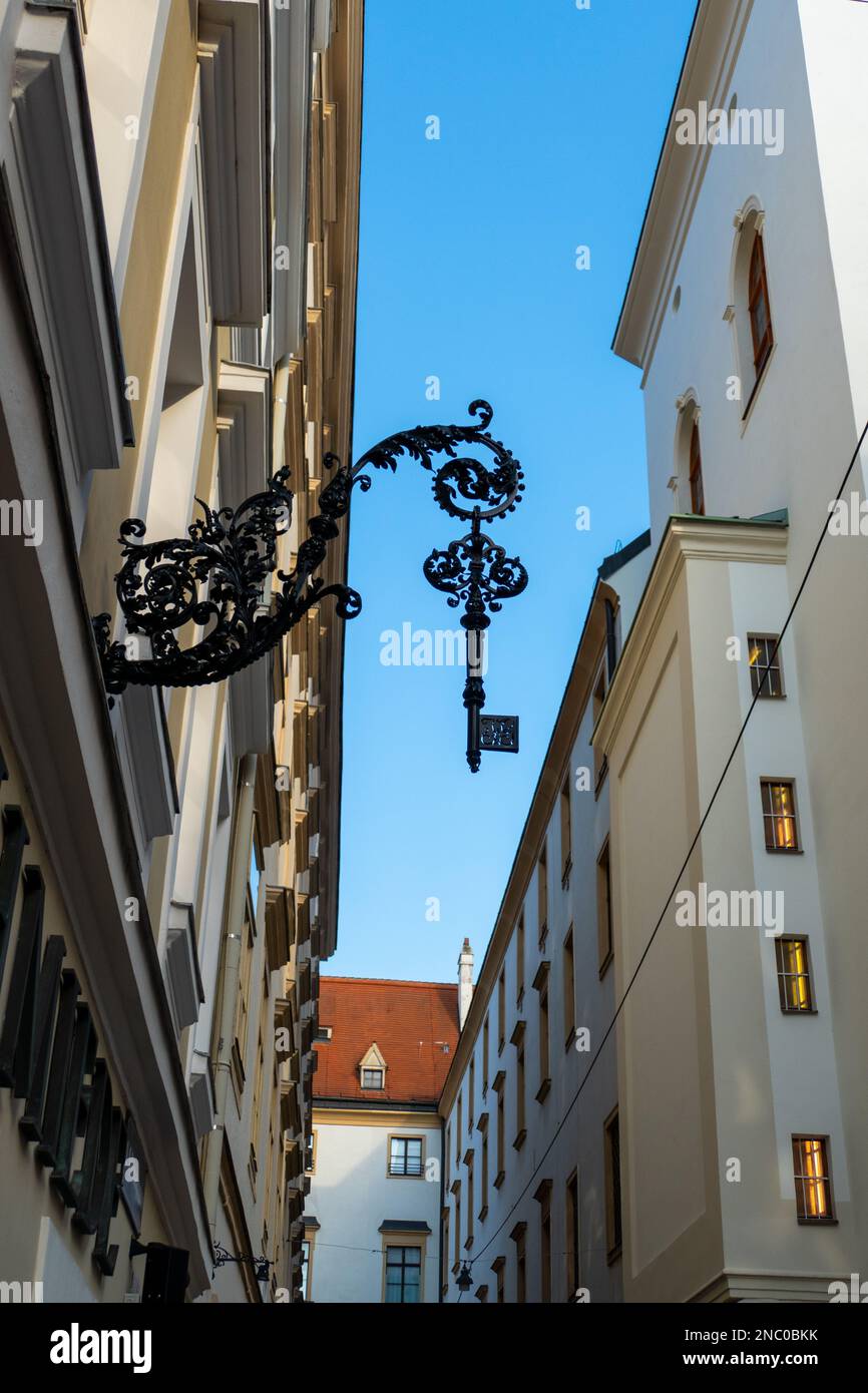 A vertical low angle shot of a ornamental black iron key hanging from ...