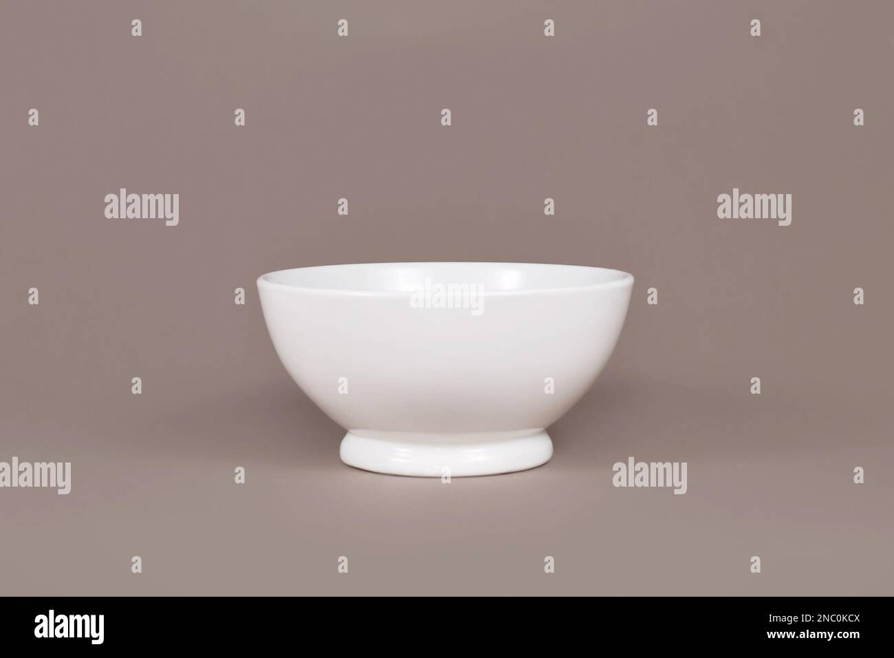 Single empty cereal bowl on brown background Stock Photo