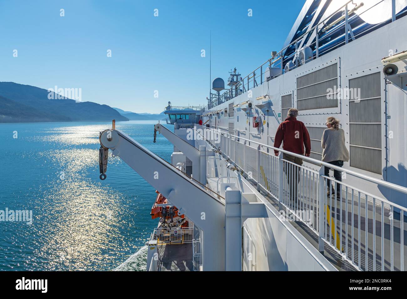 Tourist people walking on deck of a cruise ferry ship along the Inside Passage between Prince Rupert and Port Hardy, British Columbia, Canada. Stock Photo