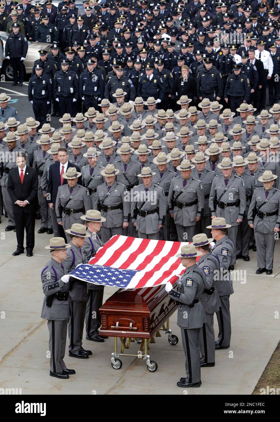 New York State Troopers fold the flag covering the casket of New York