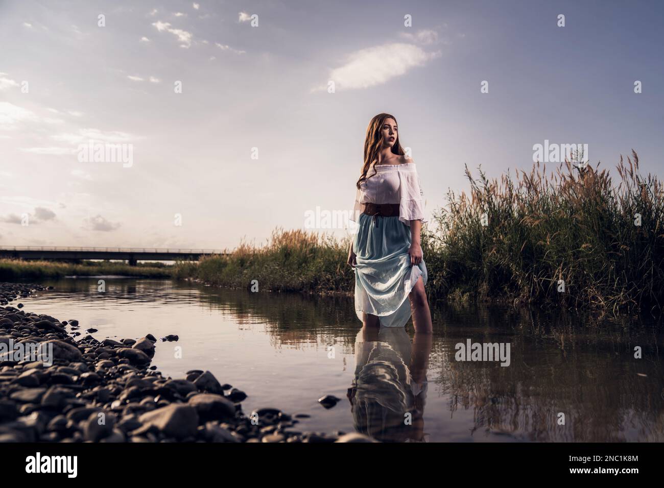 A young female standing in  river Stock Photo