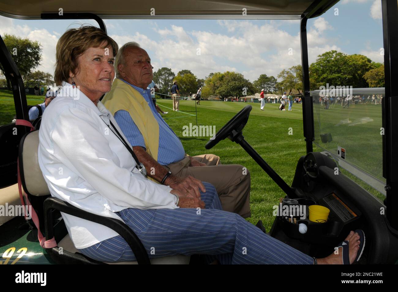 Arnold Palmer, and wife Kit, left, watch from a cart along the 18th fairway while following Palmers grandson, Sam Saunders, in the orange shirt, during the first round of the Arnold Palmer