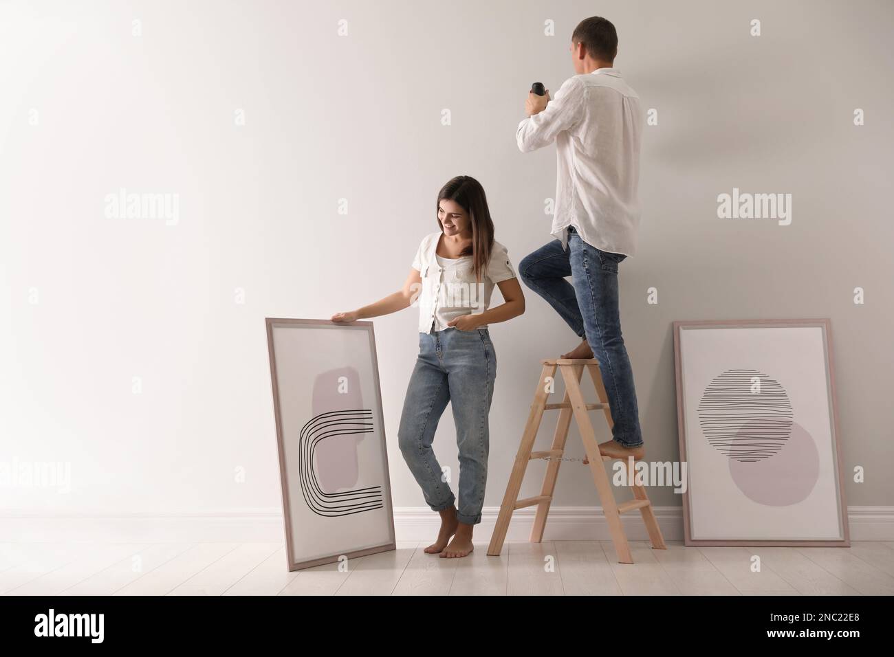 Couple decorating room with pictures together. Interior design Stock ...