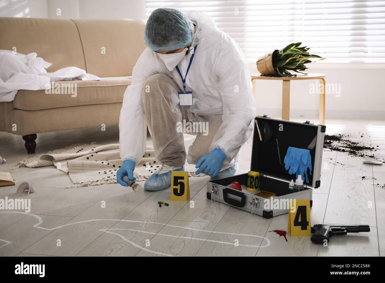 Investigator in protective suit working at crime scene Stock Photo