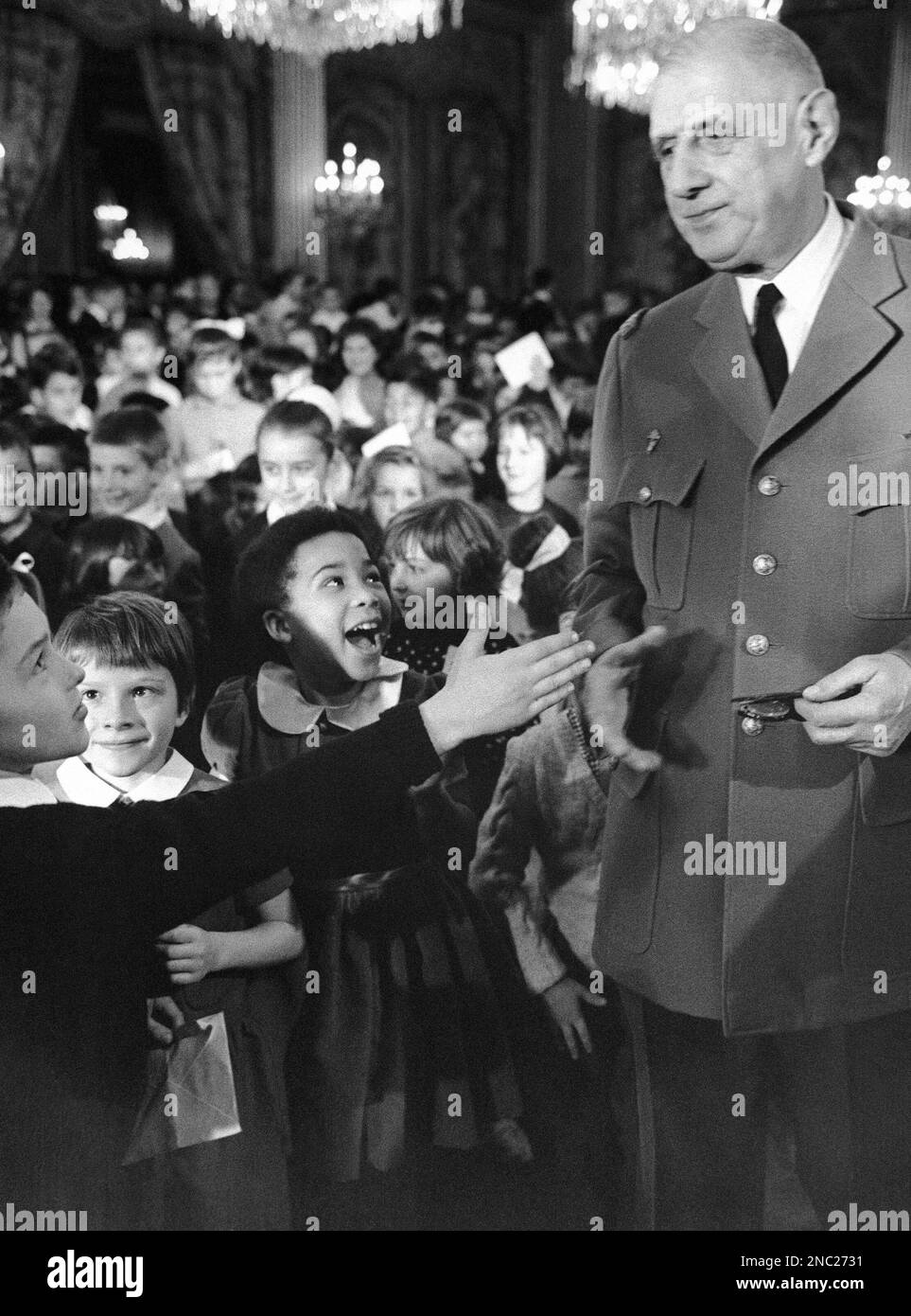 French President Charles de Gaulle shakes hands with one of the children invited to the Elysee Palace before Christmas in Paris, France on Dec. 10, 1966. (AP Photo/Pool) Stock Photo