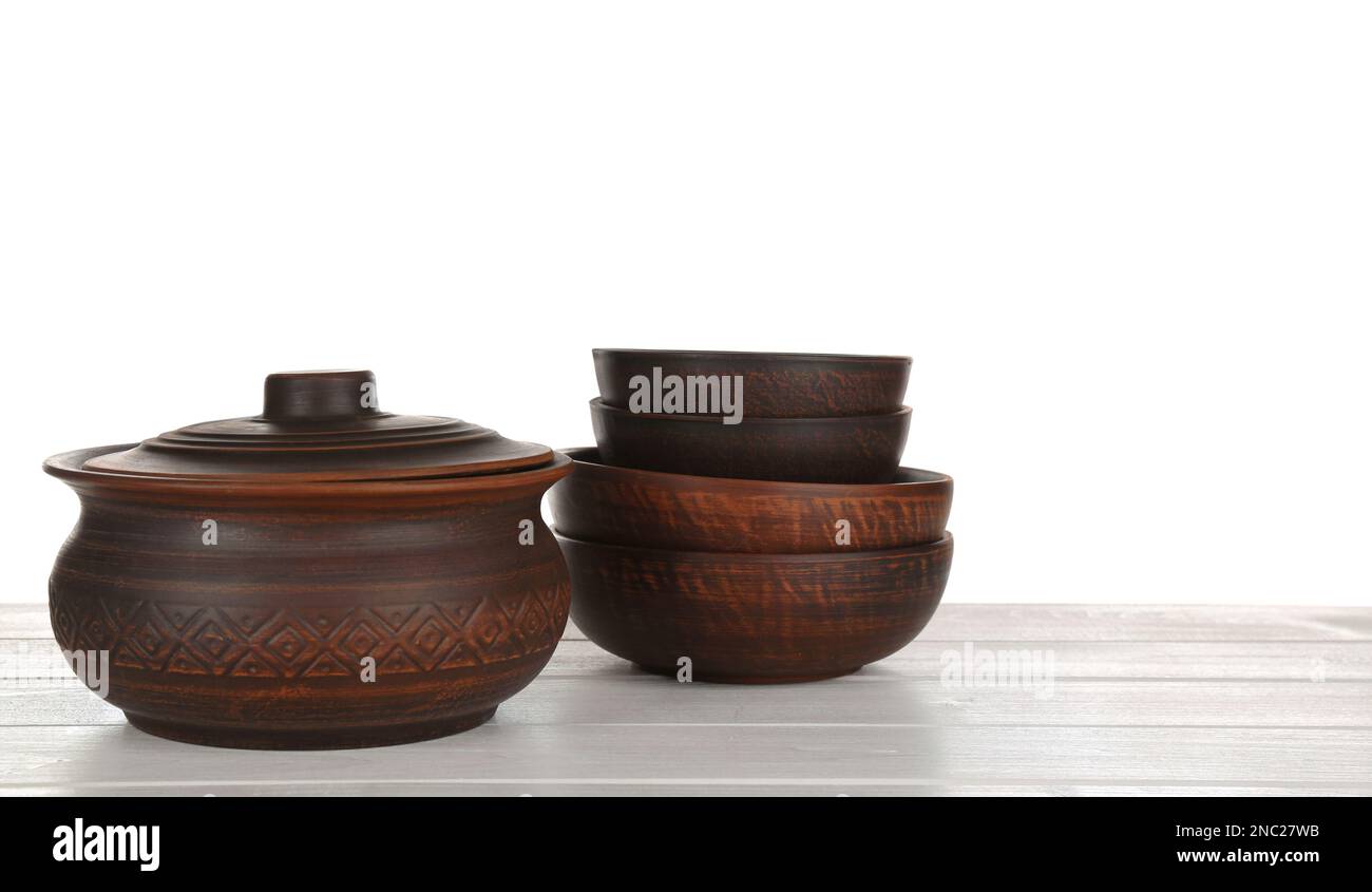 Different clay dishware on white wooden table Stock Photo