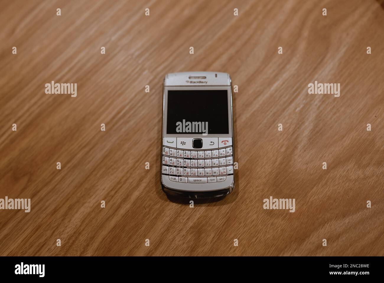 Vintage old and used BlackBerry phone from 2013 on a wooden background Stock Photo