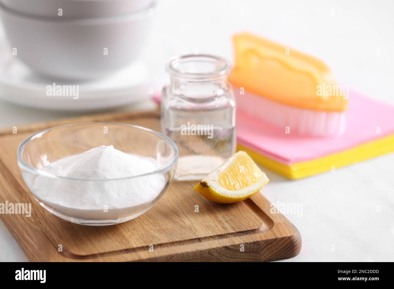 Baking soda, lemon and vinegar on white table. Eco friendly detergents