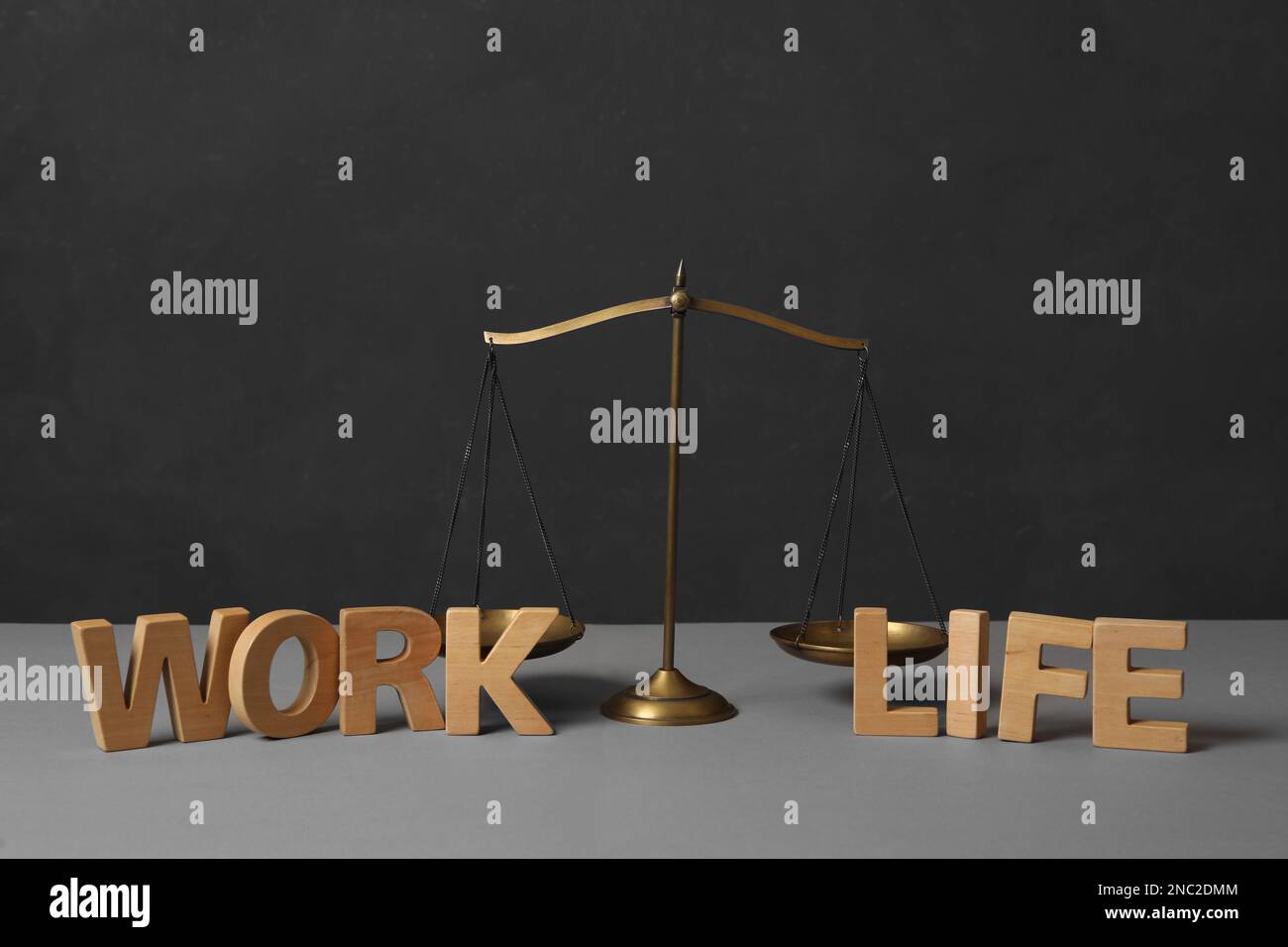 Words Life and Work made of wooden letters near scales on grey table ...