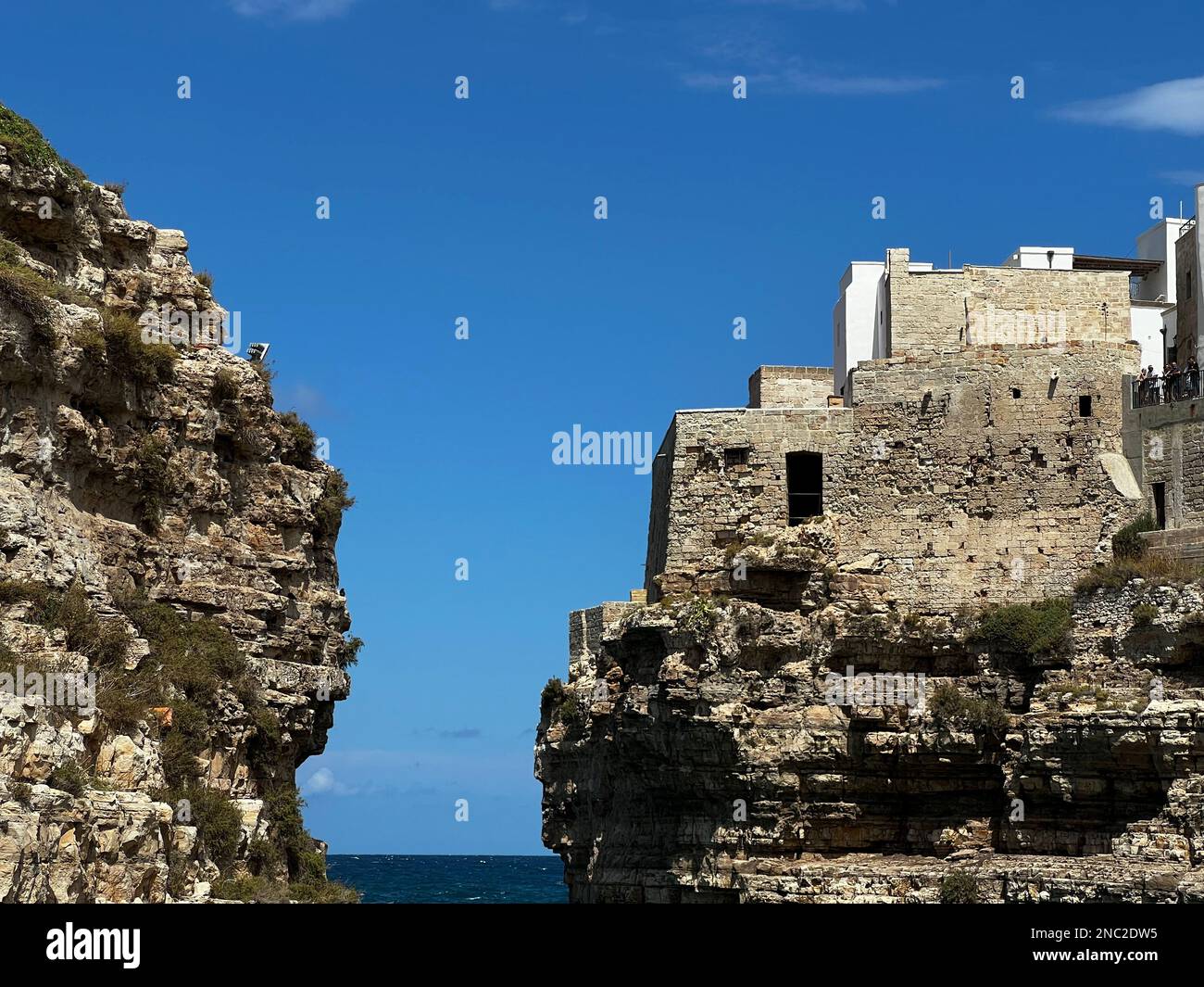 Surrounded by limestone cliffs and ancient stone buildings overlooking the sparkling watersw of the Adriatic Sea, the picture perfect Polignano a Mare Stock Photo