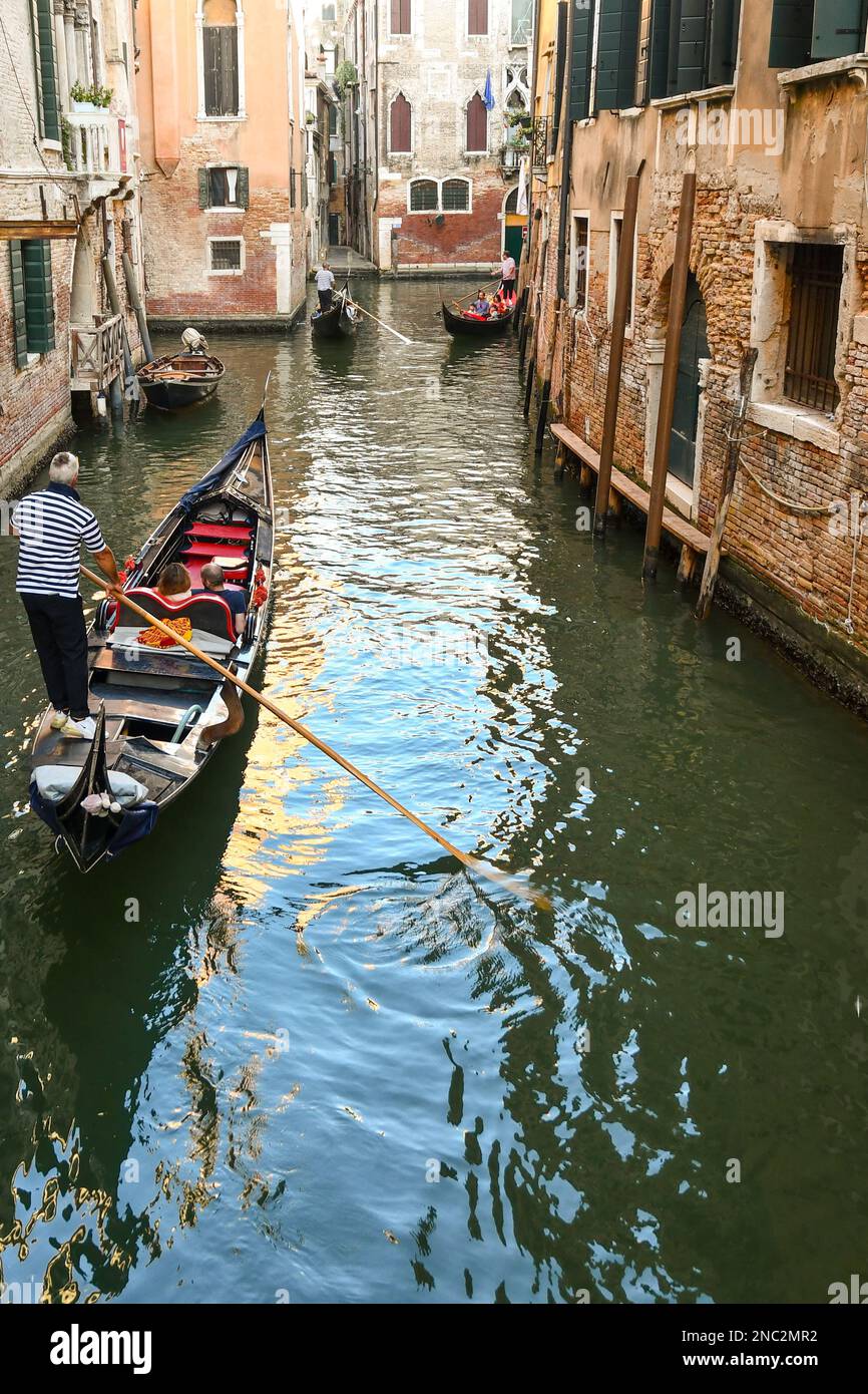 Gondolas with tourists on Rio del Fondego dei Tedeschi canal between the sestieri of St Mark and Cannaregio in summer, Venice, Veneto, Italy Stock Photo