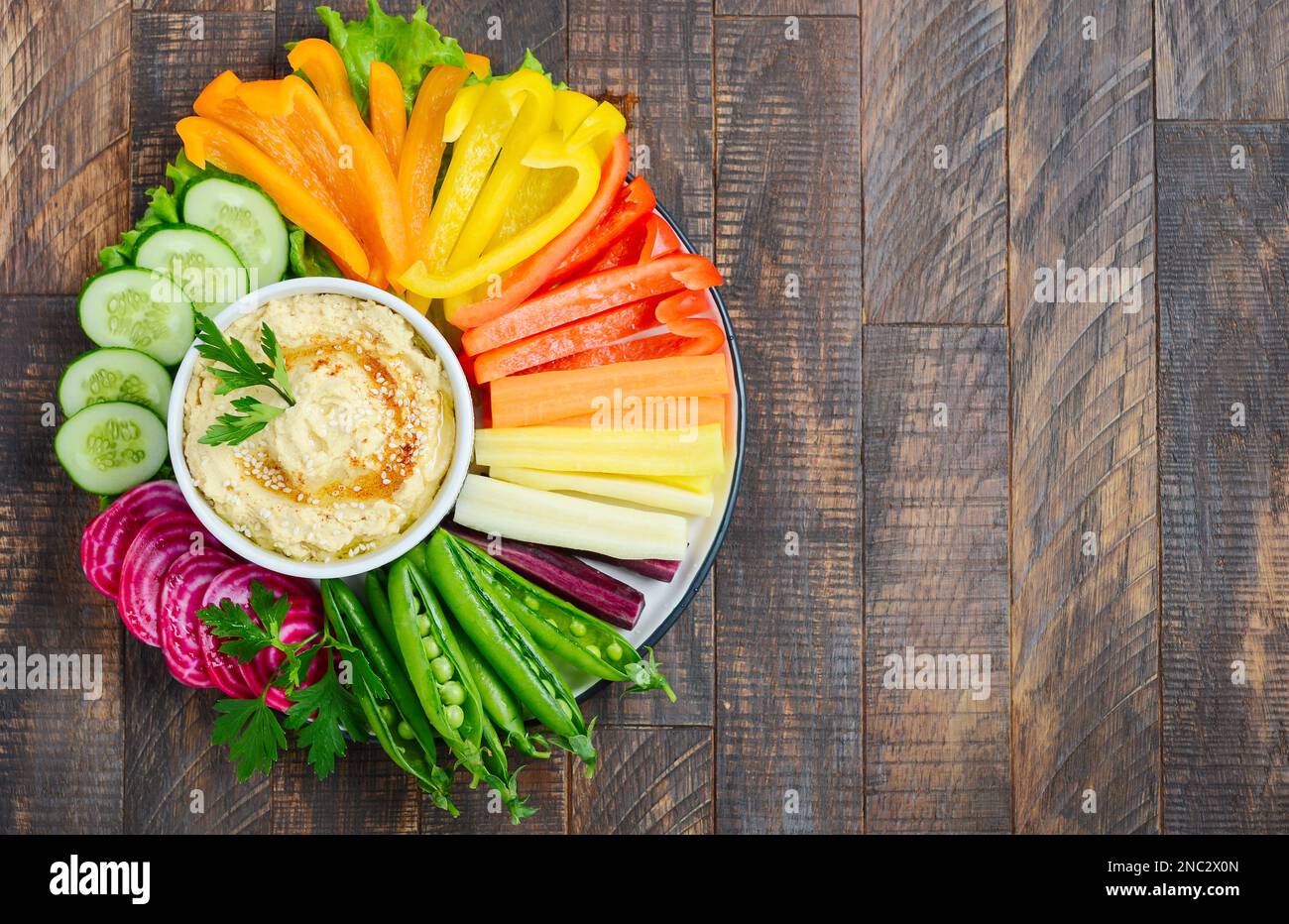 Hummus platter with assorted vegetable snacks. Healthy vegan and vegetarian food. Top view, flat lay, copy space. Stock Photo