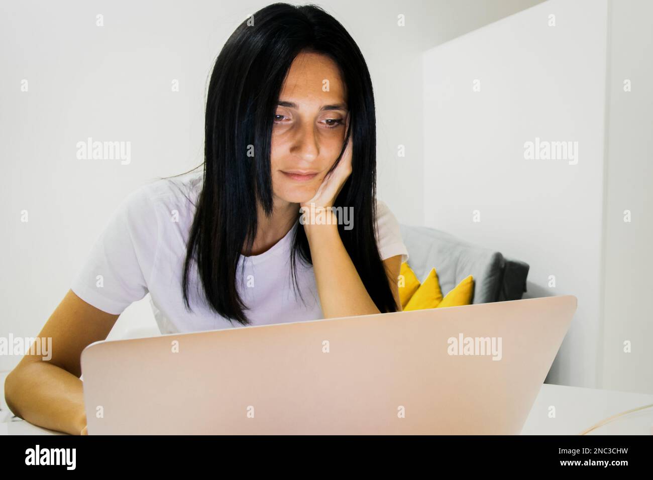 Young beautiful woman sits behind notebook computer wear white shirt ...