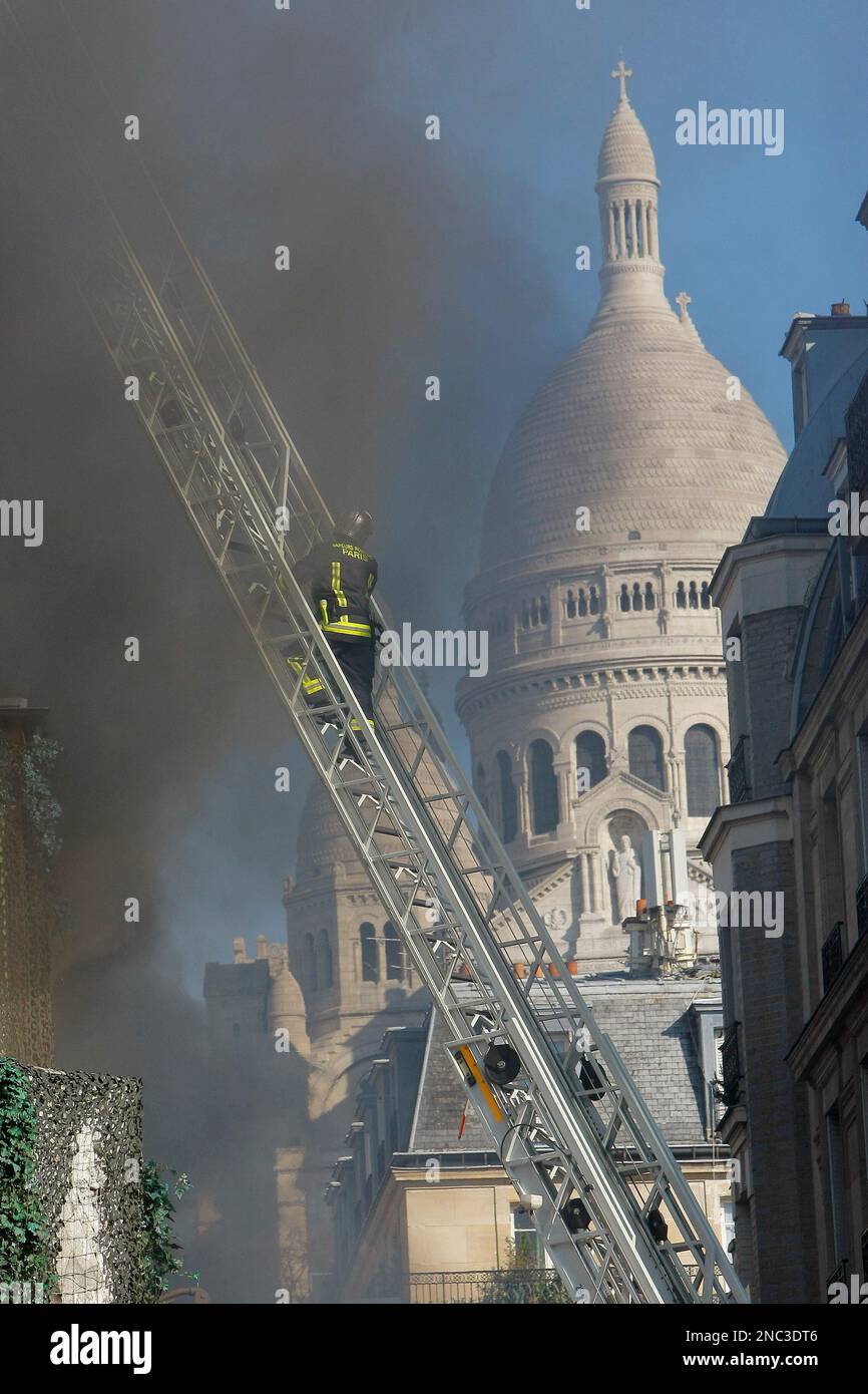 A fire fighter climbs the lader near the burning Elysee Montmartre concert  hall in Paris, Tuesday, March 22, 2011. About one hundred of firefighters  pull off the fire at the historical building