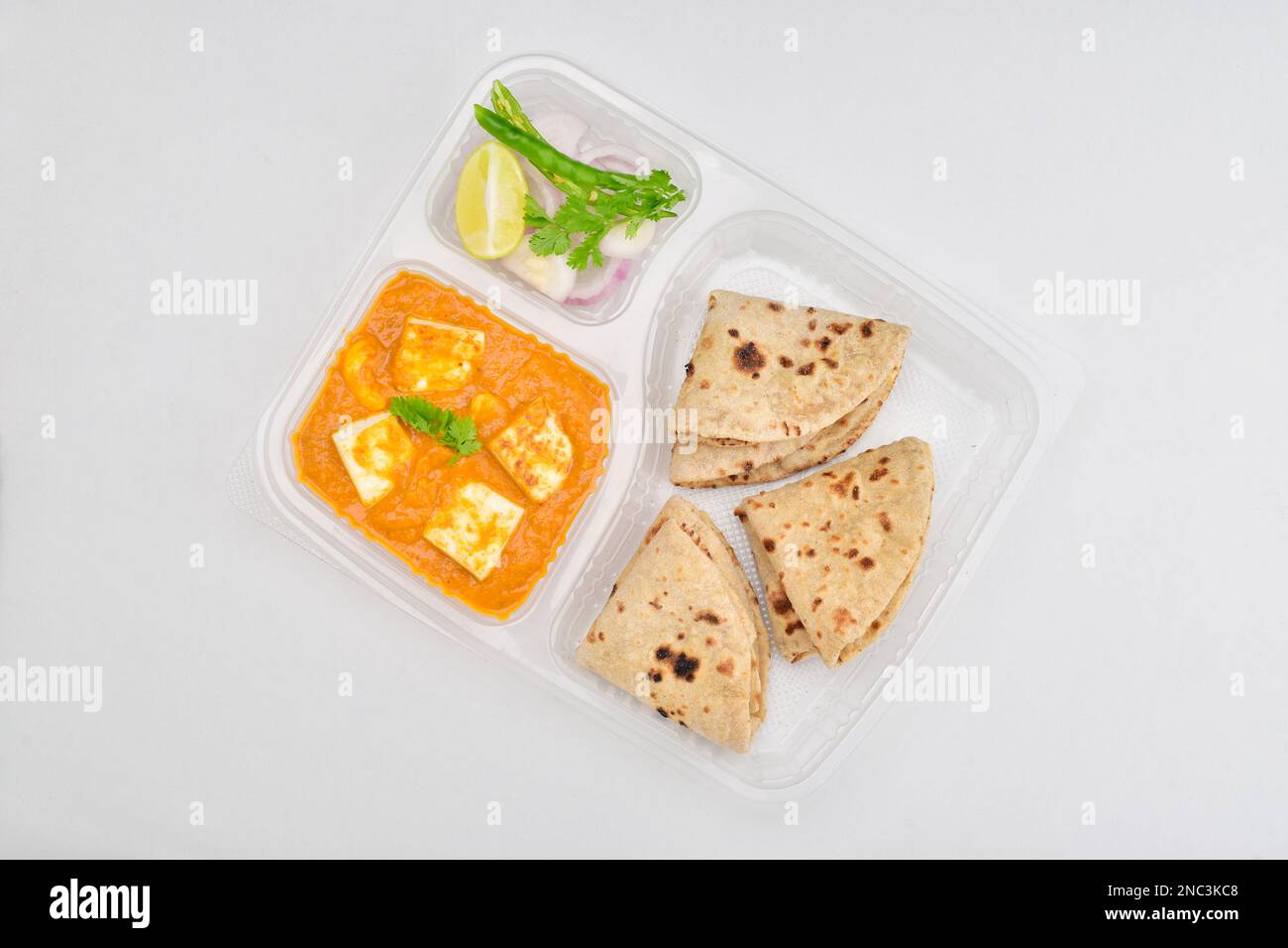 Shahi paneer and tawa roti served with onion salad in disposable thali, lunch service concept Stock Photo