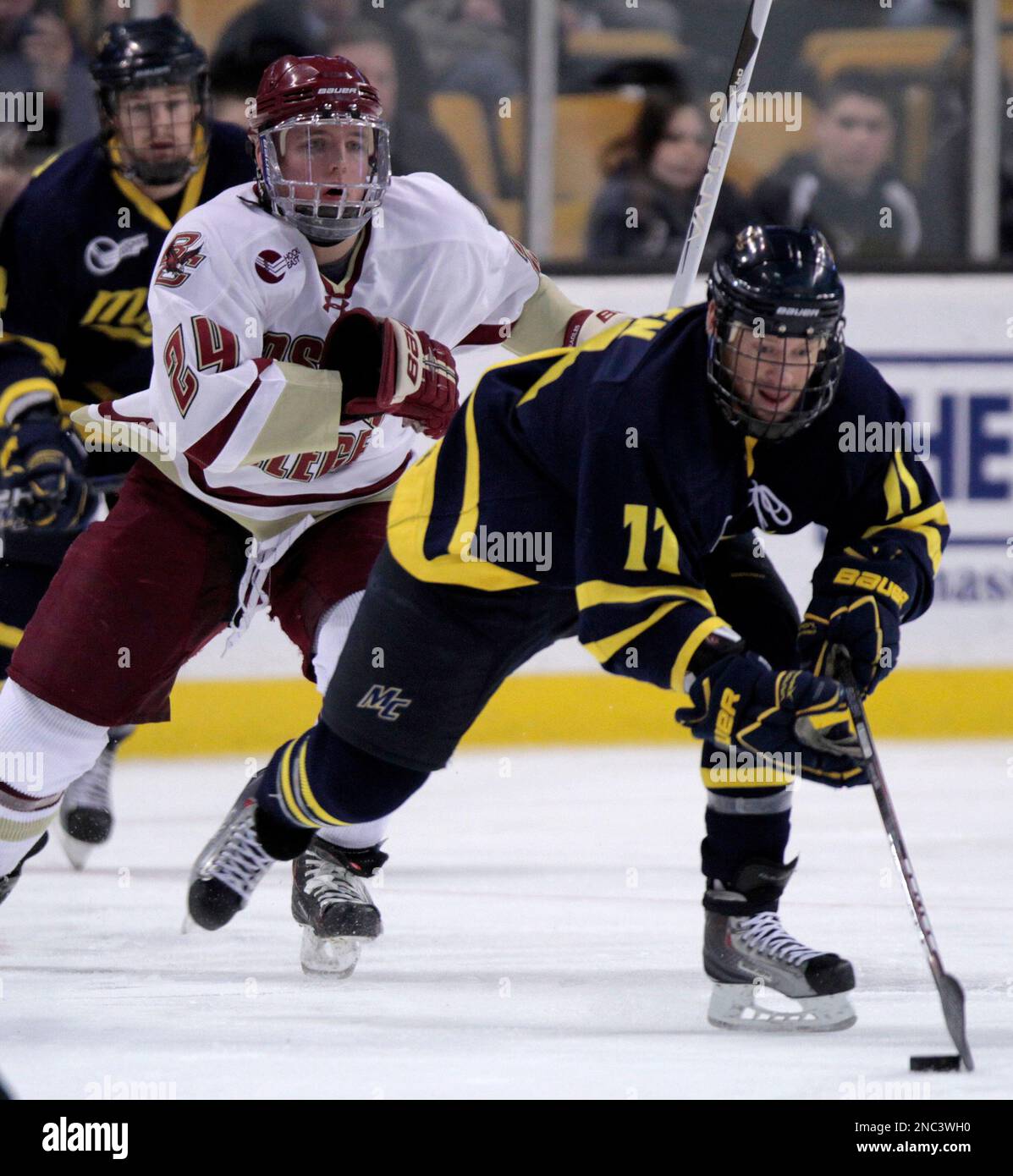 Merrimack's Elliott Sheen (11) brings the puck up ice pursued by Boston College's Bill Arnold (24) in the first period of the Hockey East tournament championship hockey game, Saturday, March 19, 2011, in Boston. (AP Photo/Michael Dwyer) Stock Photo