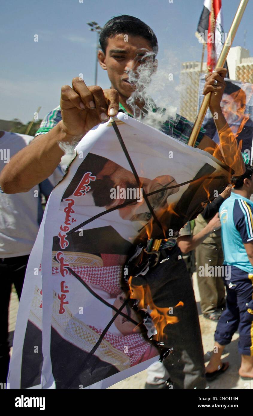 Saudi Anonymous A protester burns posters depicting King Abdullah of Saudi Arabia and ...