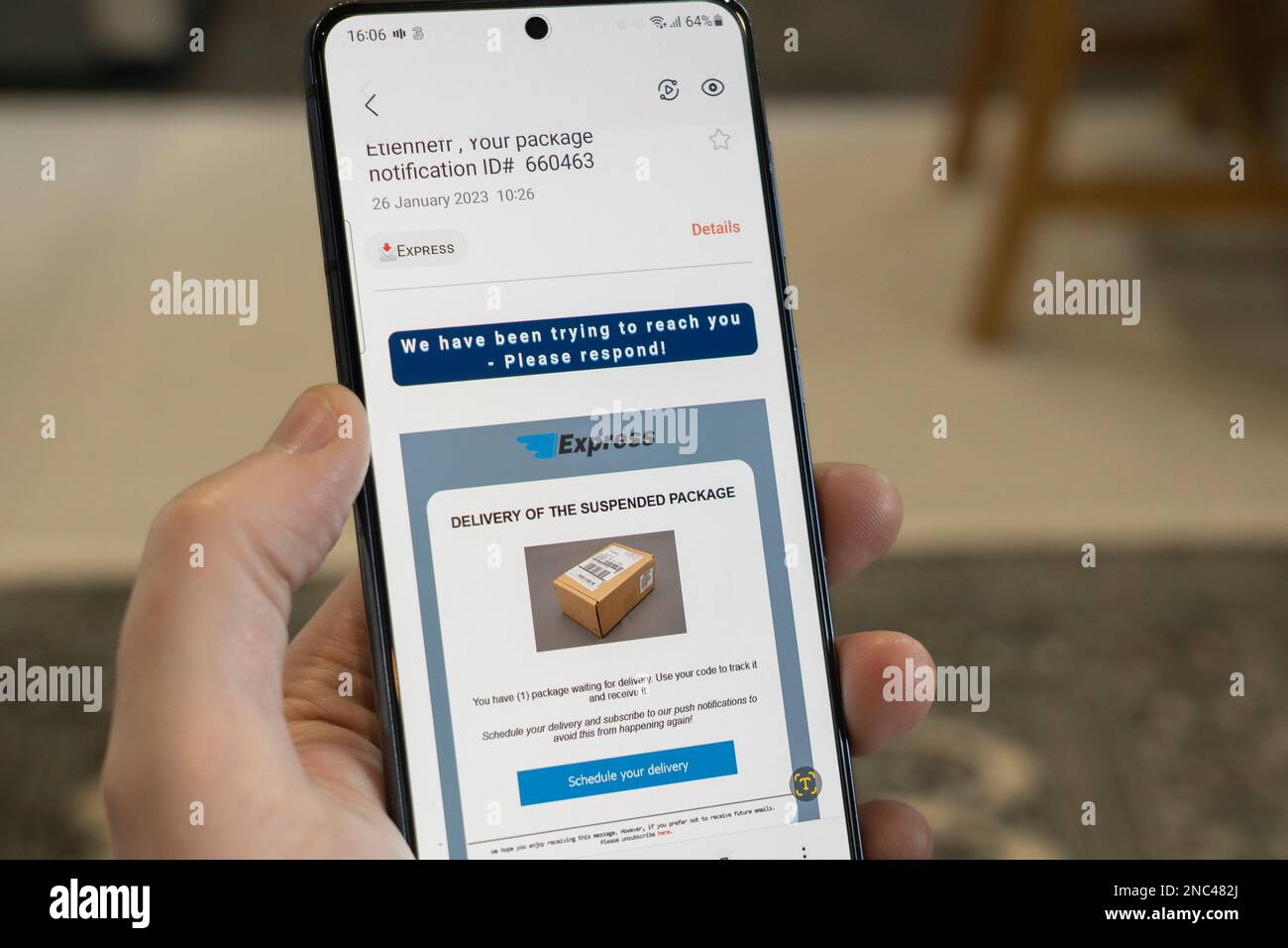 Hand holding a smartphone with a fake parcel delivery company name phishing email from scammers aiming to obtain personal data and information Stock Photo