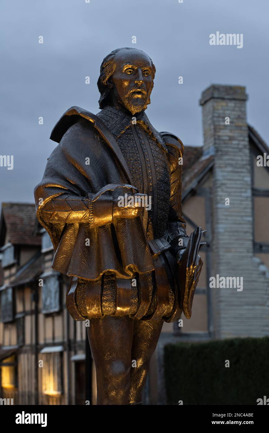 Bronze statue of the Bard William Shakespeare illuminated at night and located adjacent to his birthplace on Henley Street in Stratford-upon-Avon, UK Stock Photo