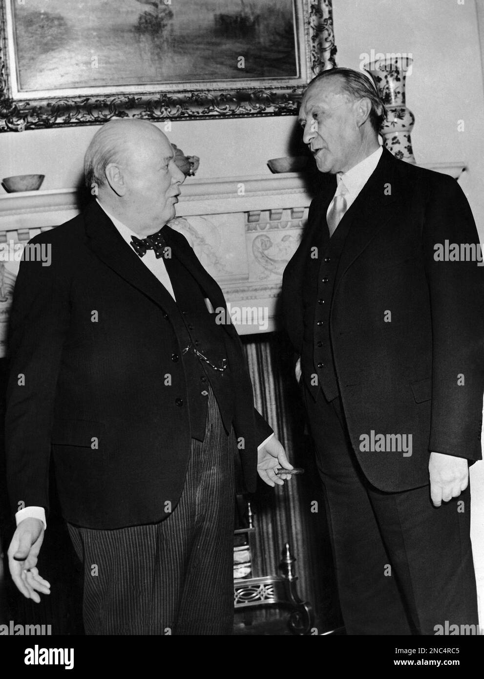 German Chancellor Konrad Adenauer talks to British Prime Minister Winston Churchill, at left holding a cigar, after breakfast during his visit to No. 10 Downing Street, London, United Kingdom on December 4, 1951. (AP Photo) Stock Photo