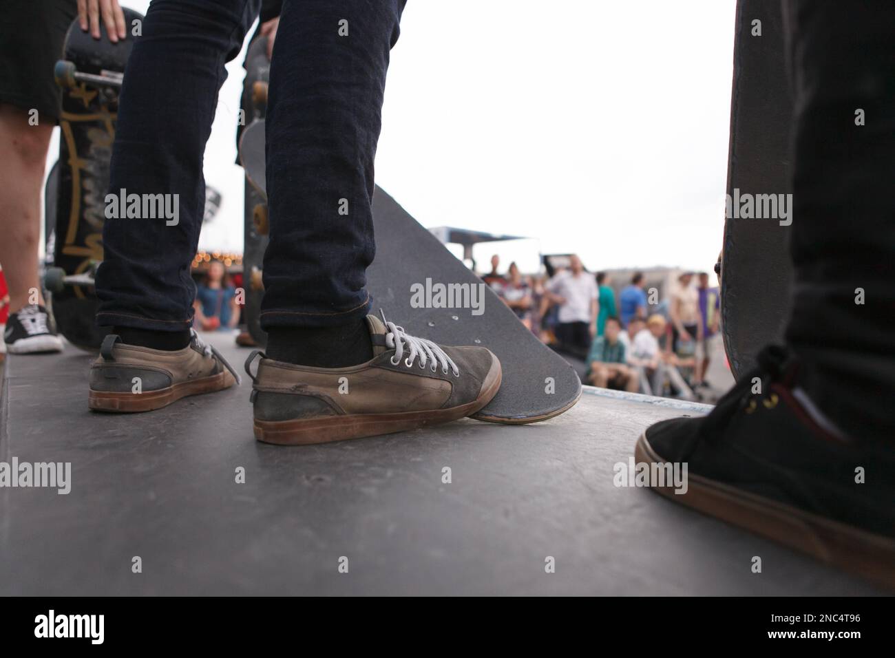 Group of dirty skaters on ramp top in skate park. Feet of young ...