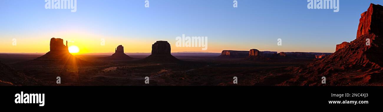 Monument Valley panoramic sunrise, with the Sun just clearing the left mitten. Stock Photo
