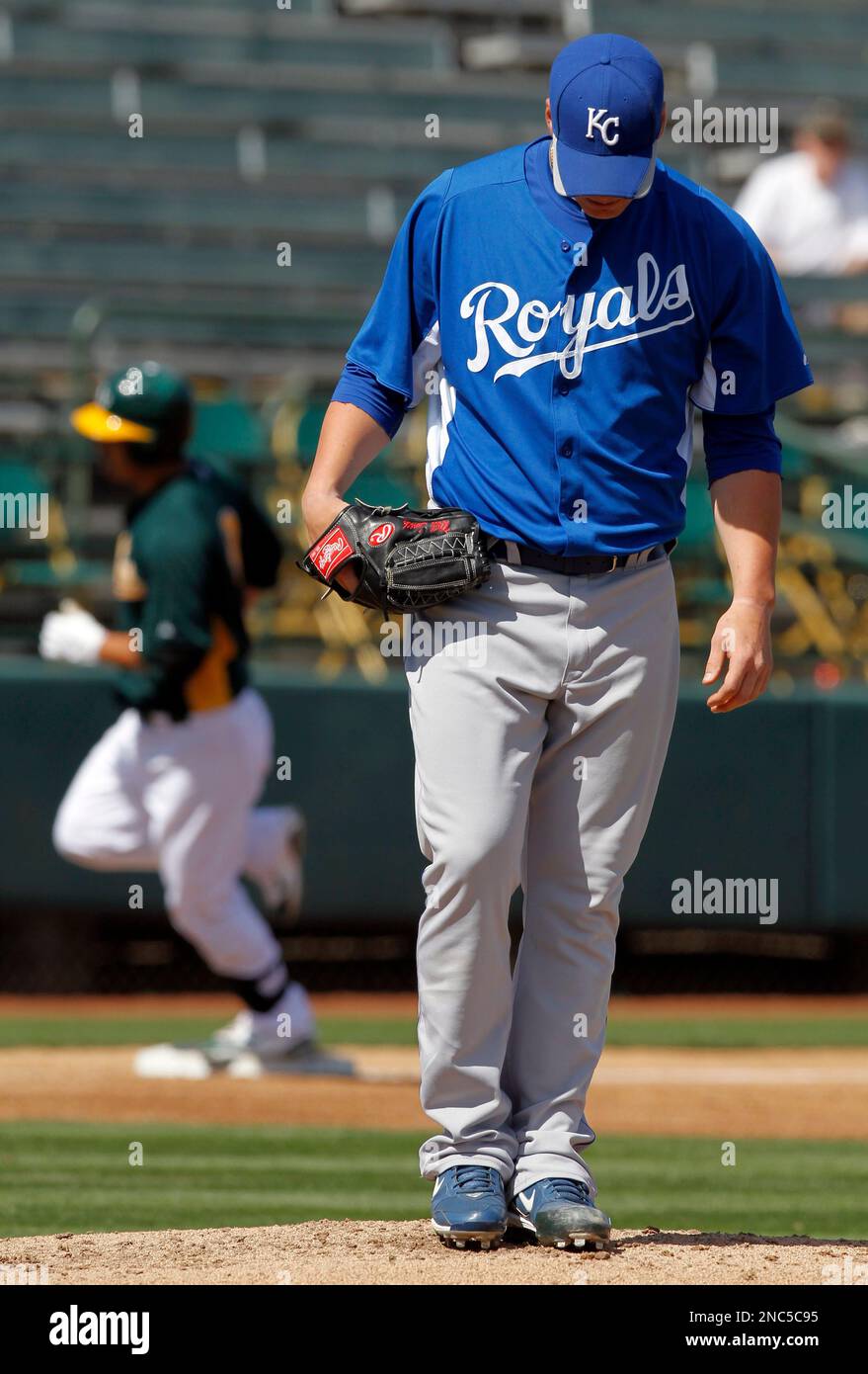 Kansas City Royals stating pitcher Will Smith, foreground, looks at the  mound as Oakland Athletics' Kurt Suzuki, background, rounds the bases after  a two-run home run during the first inning of a