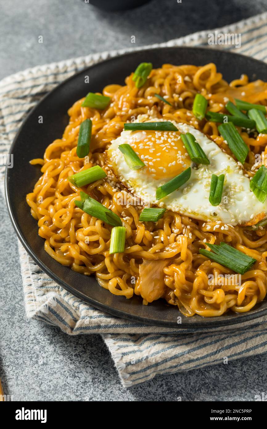 Korean Cheesy Kimchi Noodles with Soy Sauce and an Egg Stock Photo