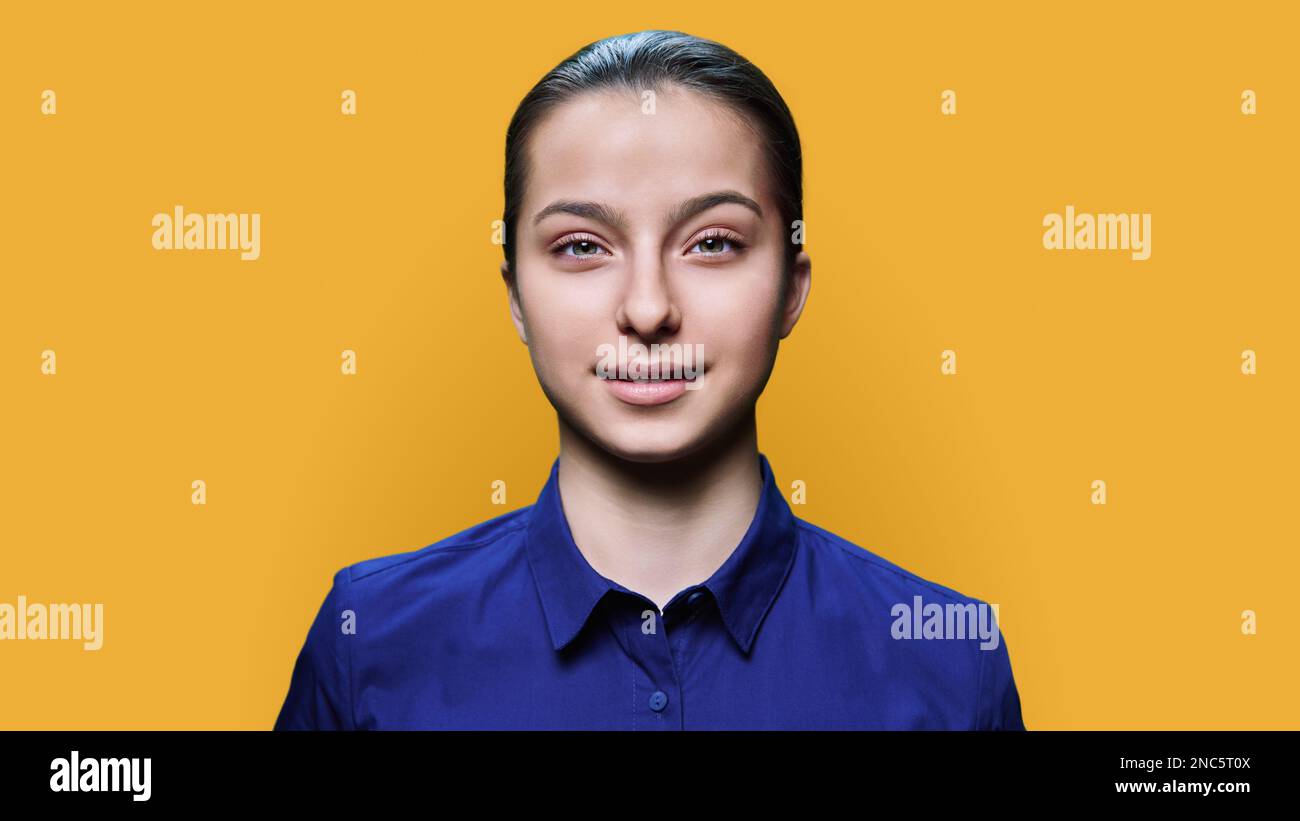 Headshot portrait of smiling teenage girl 15, 16 years old on yellow background Stock Photo Alamy